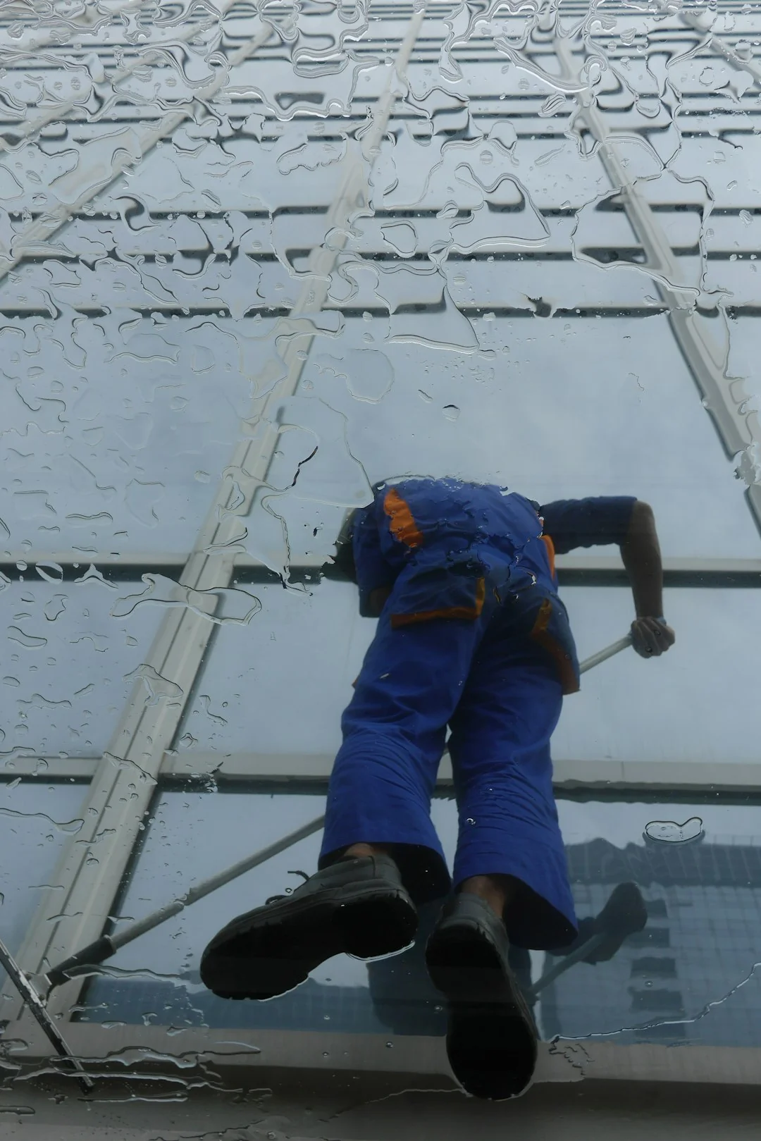 Two window cleaners using ropes on a modern skyscraper, showcasing urban professional maintenance.